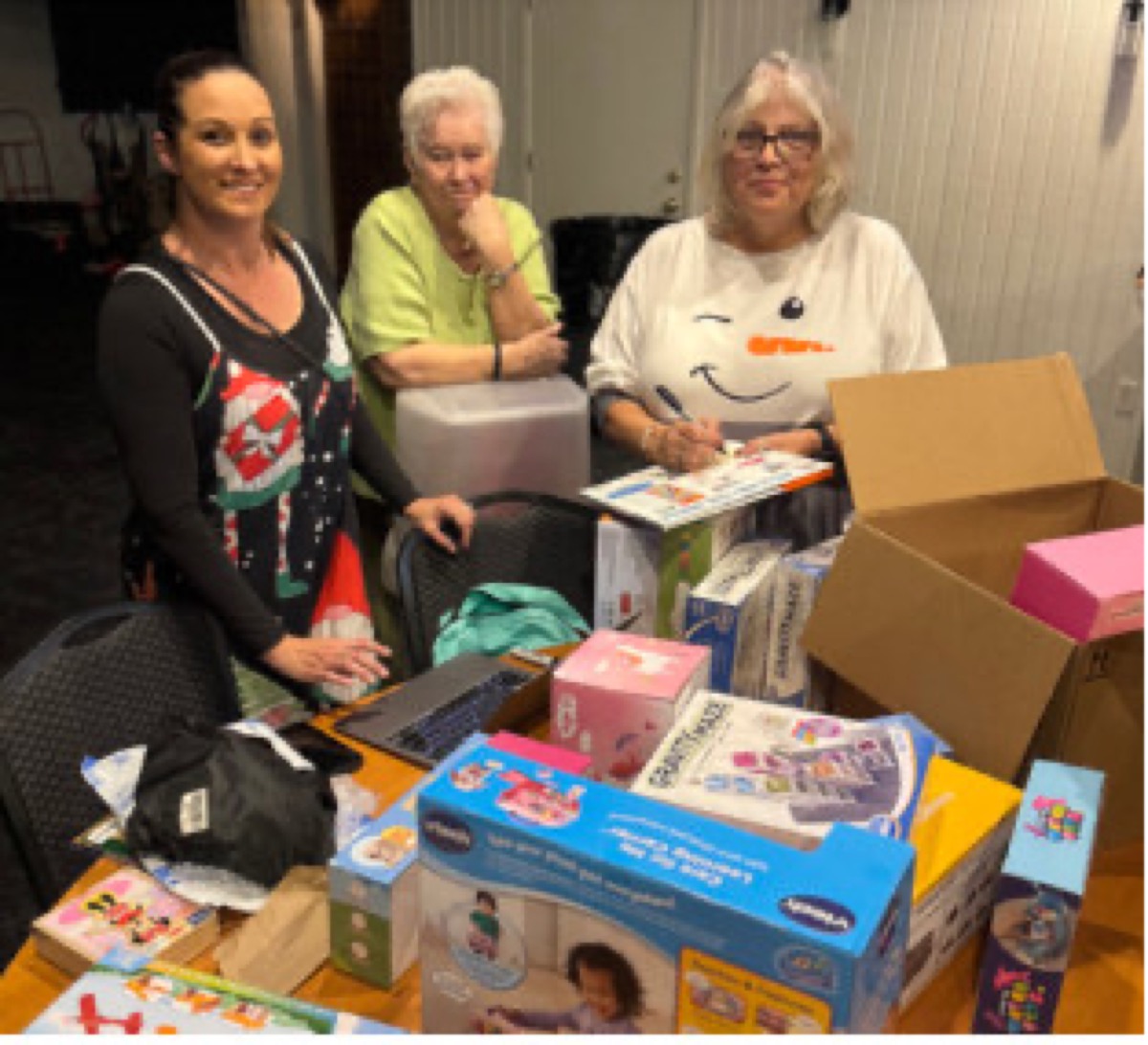 Volunteers sort donated toys and gifts for the Children's Christmas Shopping Spree